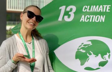 Andrea poses in front of the SDG 13: Climate Action cube